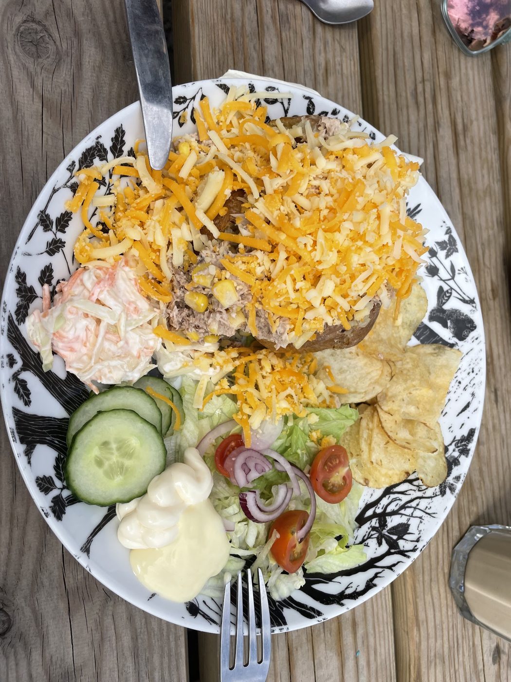 A salad plate with grated cheese, coleslaw and crisps